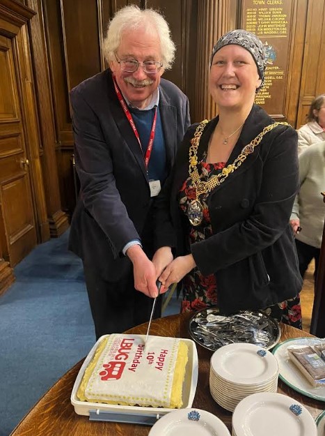 Two people cutting a birthday cake